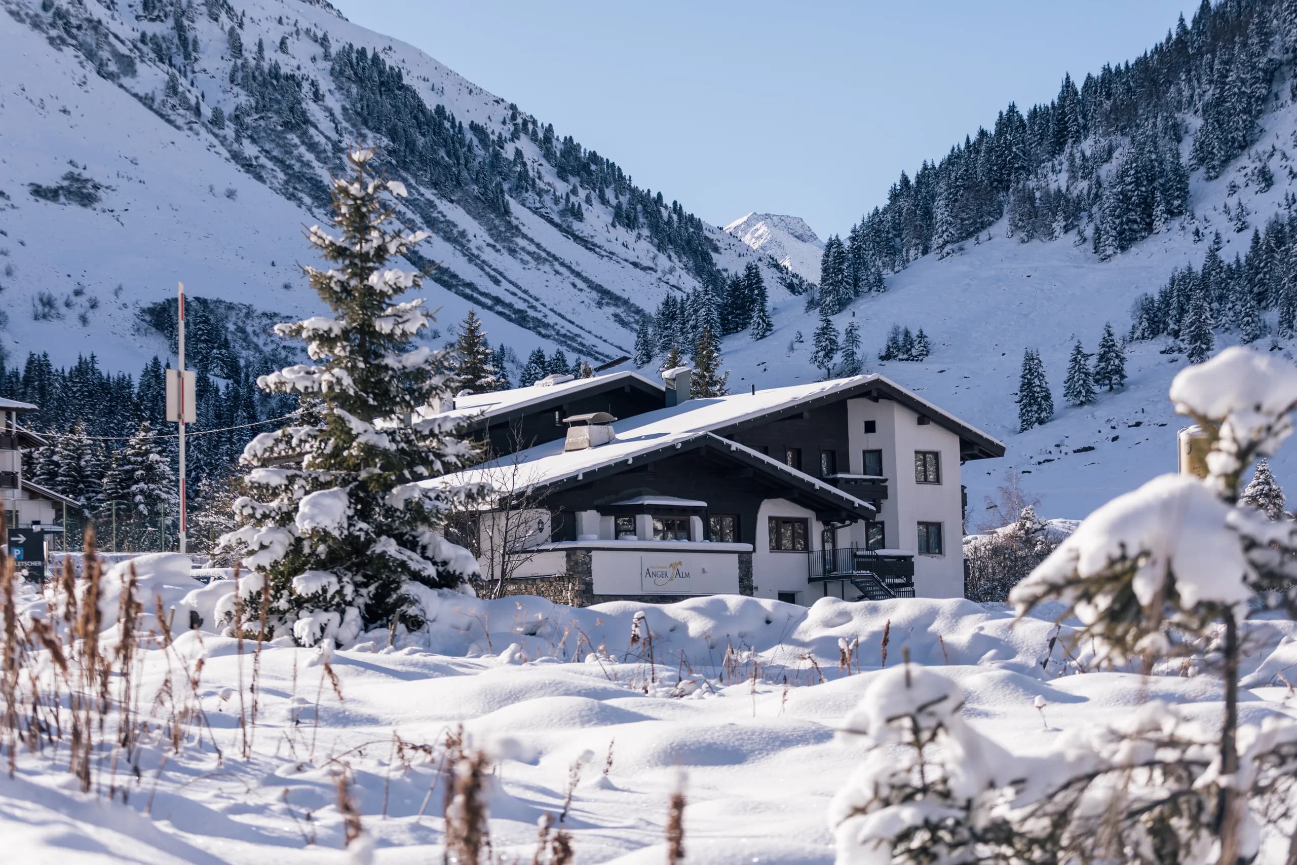 Verschneite Hausfassade der Natur Residenz Anger Alm im Winter
